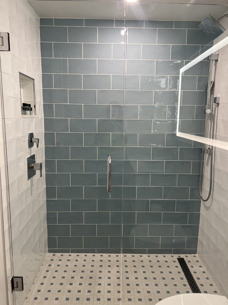 spacious shower with blue tile